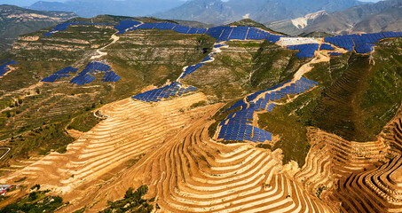 Aerial photography of blue solar photovoltaic panels on mountain