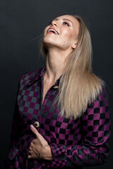 Fashion and make-up concept. Beautiful brunette woman with checkered black and purple suit studio portrait. Model with day make-up looking looking up with joy or excitement in her face