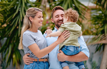 Family, love and parents with child in garden with smile, happy and hug together in summer. Excited, relax and loving mother and father on outdoor holiday with a kid in a park, nature or backyard
