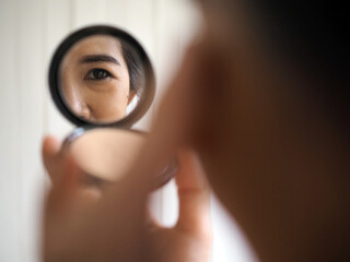 woman looking through magnifying glass