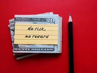 Pencil and cash dollar money on red background with handwritten note NO RISK NO REWARD - means...