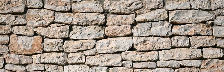 Fondo con detalle y textura de muro de piedras naturales en tonos marron suave
