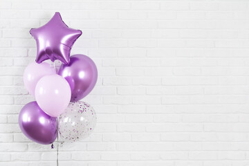 Bunch of purple balloons on white brick wall texture background