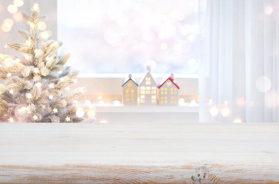 Christmas table top in front of blurred decorated window background