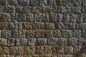 Old wall of natural stones. The ancient wall is made of rectangular natural stones.
