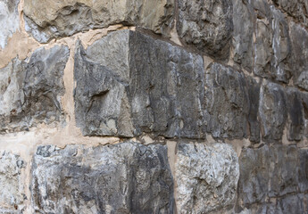 An old wall built of rectangular stones. Stone wall corner.