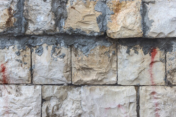 Old masonry with traces of mortar. An old wall built of rectangular stones.