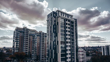 Fototapeta na wymiar Modern residential buildings district cityscape in autumn with epic evening cloudy sky. Downtown Kharkiv city, Ukraine
