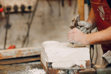 Man sculptor creates sculpt bust gypsum human woman sculpture. Statue craft creation workshop