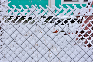 Mesh fence after a snowfall close-up