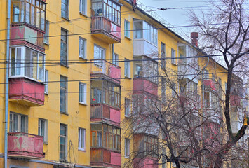 Fototapeta na wymiar Fragment of the facade of an old apartment building on a rainy autumn day