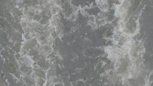 Industrial wastewater and foam. Discharge of polluted wastewater into the river. Hazardous waste water. Drone top view shot. Slow motion 120 fps, ProRes 422, 10 bit ungraded DJI D-LOG video