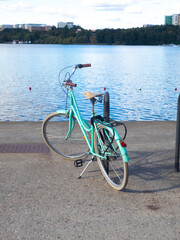 Old bike for women parked by a lake