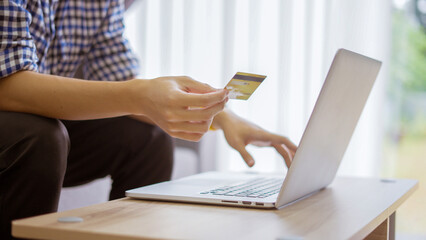 Men holding credit card and Shopping on Laptop at home