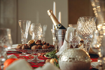 Beautifully served festive Christmas table with champagne and nuts. New Year's decor. Christmas table setting.