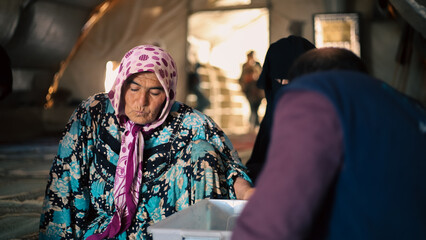 An elderly refugee performs a medical examination inside a makeshift medical tent in the camp.
