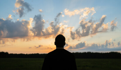 A man in nature looks at the sky and relaxation