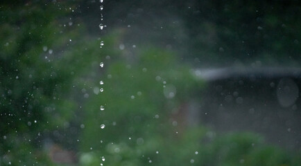 Raindrops are dripping from the roof in the air.Frozen shooting of rain.Rainy weather.