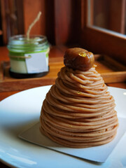 Close up of chestnut cream cake with green tea latte on wooden table