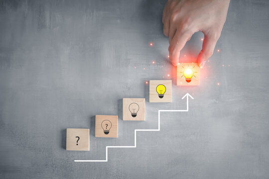 Idea and creativity concept. Creative process concept and problem solution. Hand pick glowing light bulb  from step of question mark on stair to glowing light bulb for solving problem.