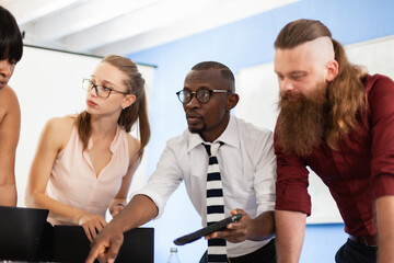 Multiracial business people working together at boardroom table at office. Successful team of colleagues brainstorming..