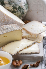 Closeup assortement of slices of soft cheeses on wooden board. Farm goat soft cheese background. Cornish Yarg cheese .