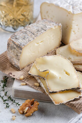 Closeup assortement of slices of soft cheeses on wooden board. Farm goat soft cheese background. Cornish Yarg cheese .