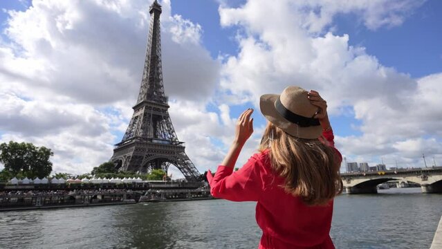 Holidays in Paris. Back view of beautiful fashion girl enjoying view of Eiffel Tower in Paris, France. Summer vacation in Europe.