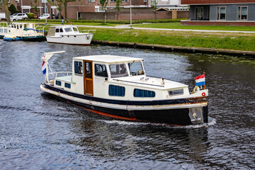 Recreational boat on a canal in the Netherlands on a cloudy summer day. Water.