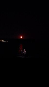 giant moon rising on the sea with couple