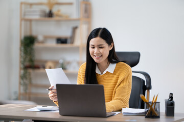 Happiness Attractive Asian woman in yellow shirt working with computer laptop thinking to get ideas and requirement in Business startup at modern office or Co-working space,Business Startup Concept
