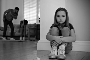 Couple fighting at home, focus on their unhappy little daughter. Domestic violence