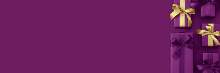 Gift boxes with purple and golden ribbon. Black Friday banner. Packaging and preparation of gifts for the celebration. Copy space