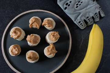 Pre workout snack for muscle building with sliced banana and crunchy peanut butter