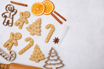 Christmas treat. Flat lay composition with cookie cutters and dough on light table, space for text