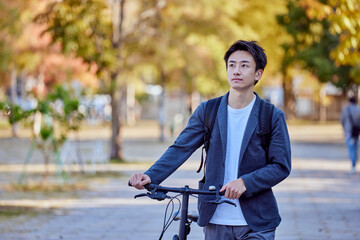 自転車に乗るジャケットを着た若い日本人の男性