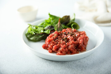 Traditional homemade steak tartare with leaf salad