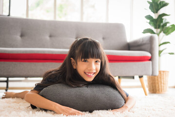 Young child girl kid lying on pillow with smile and happiness in living room.