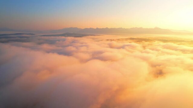 Aerial view from a drone flying over heavy dense fog during sunrise, Mountain scenery and sky in the background. amazing scenery in golden hour. Chiang Mai, Northern Thailand. 4K. nature concept
