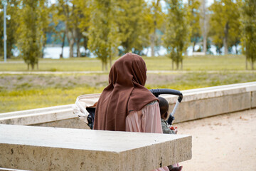Muslim black mommy with her baby in the park. Spanish migration
