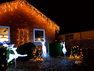 Danish home decorated with christmas lights and ornaments outside the house and in the garden in December