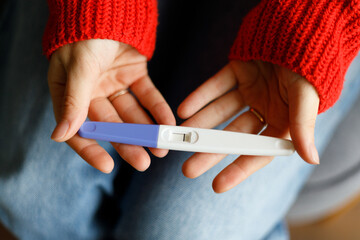 Negative pregnancy test with one strip in female hands, close-up. - obrazy, fototapety, plakaty