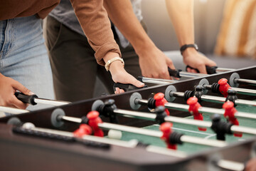 Hands, foosball and table with friends playing a game together indoors for fun or recreation....