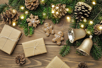 Christmas tree branches, gingerbread cookies, gift boxes and ornaments on wooden background