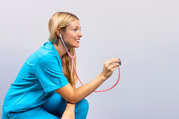 Nurse in blue scrubs using stethoscope on an invisible patient