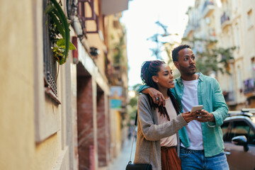 Fototapeta na wymiar Affectionate couple with smartphone on street.