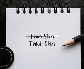 Pencil on notebook written THIN SKIN and THICK SKIN, self reminder to develop thicker skin, stop...