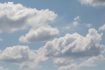 White clouds on the blue sky, bright background of the summer sky.