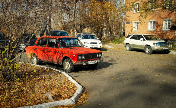 kazakhstan, Ust-Kamenogorsk, october 15, 2022: Cars parked in the parking lot. Vaz 2106 Zhiguli. Red Lada 1600. Old apartment buildings