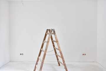 Leiter vor weißer Wand nach Malerarbeiten im Haus